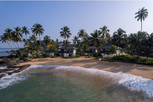 Luxuriöses Boutique-Hotel am Strand in Sri Lanka mit Palmen und sanften Wellen am Ufer