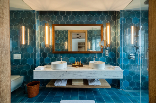 Luxuriöses Badezimmer mit Doppelwaschbecken, großem Spiegel und blauen sechseckigen Fliesen im Boutique-Hotel am Strand in Sri Lanka