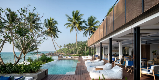 Luxuriöses Boutique-Hotel mit Infinity-Pool und Liegestühlen am Strand in Sri Lanka, umgeben von Palmen