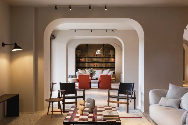 Hotel-Lounge mit modernen Sitzmöbeln, zwei roten Sesseln, einem Schachbrett auf dem Tisch und dekorativen Bögen
