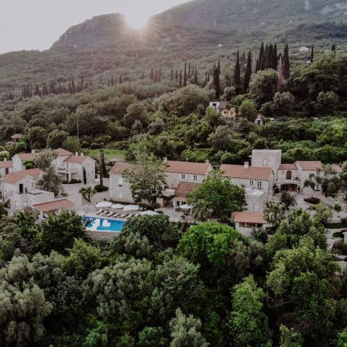 Hotel Malo Selo eingebettet in bewaldete Hügel mit Pool und umliegenden Gebäuden unter Bergkulisse