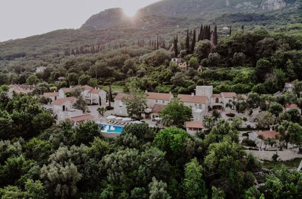 Hotel Malo Selo eingebettet in bewaldete Hügel mit Pool und umliegenden Gebäuden unter Bergkulisse