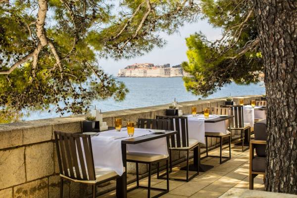 Terrasse des Gardino Restaurants mit gedeckten Tischen und Blick auf das Meer und die Altstadt von Dubrovnik
